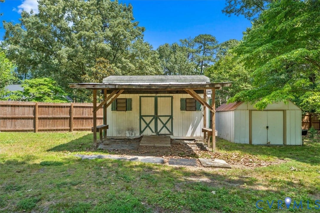 2924 Warfield Ridge Terrace, Chester, VA 23831 Two storage sheds, including one with a covered porch area, are situated on a grassy lawn