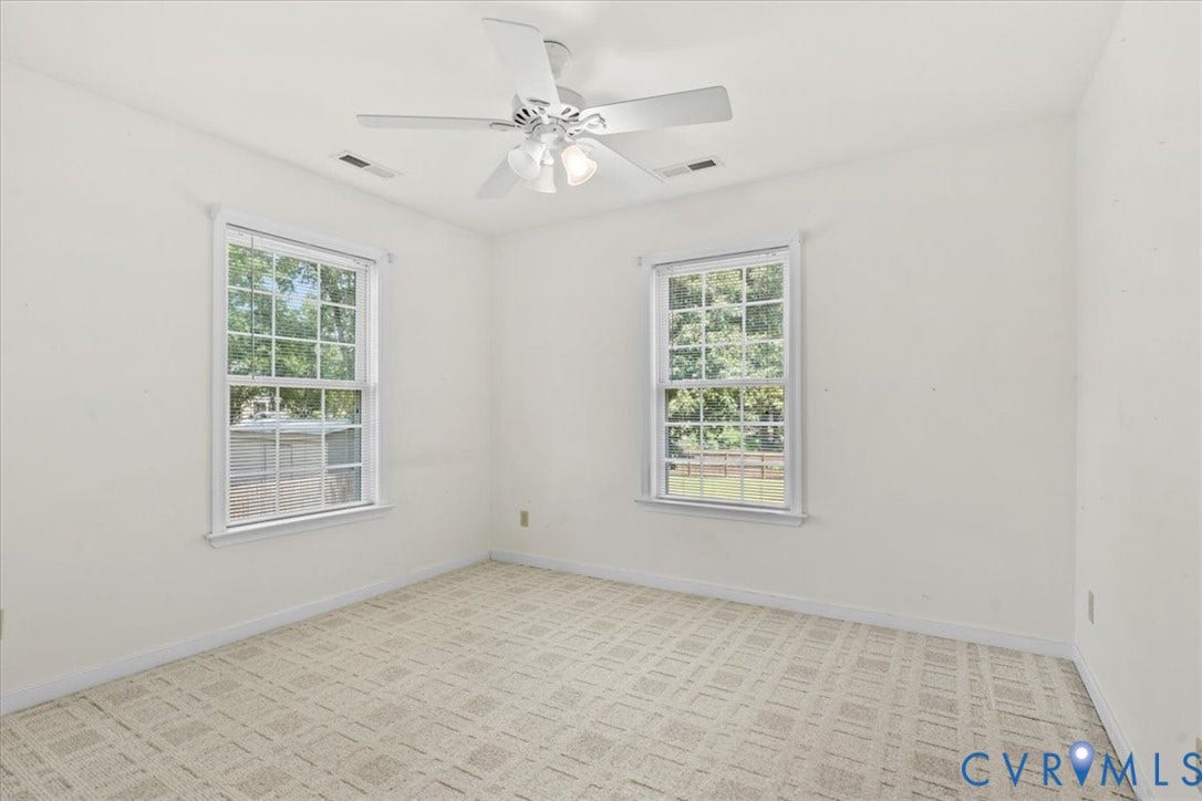 2924 Warfield Ridge Terrace, Chester, VA 23831 Bright room featuring two windows, neutral wall color, patterned carpeting, and a ceiling fan with integrated lighting