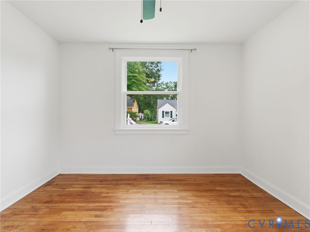 Room featuring light wood-finish flooring, white walls, and white trim