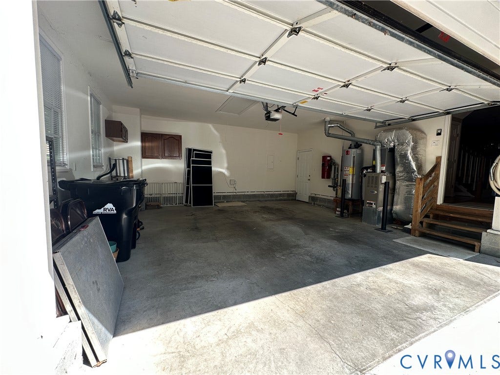12112 Kershaw Place, Wyndham, Glen Allen, VA 23059 Attached garage with concrete flooring, two windows, and wood cabinetry