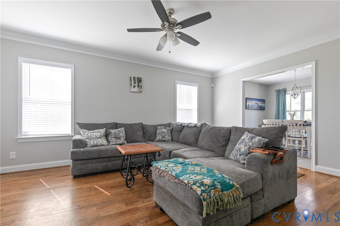 1301 Dance Street, Randolph, Richmond, VA 23220 Spacious living area featuring wood-finish flooring, two windows with blinds, a ceiling fan, and crown molding