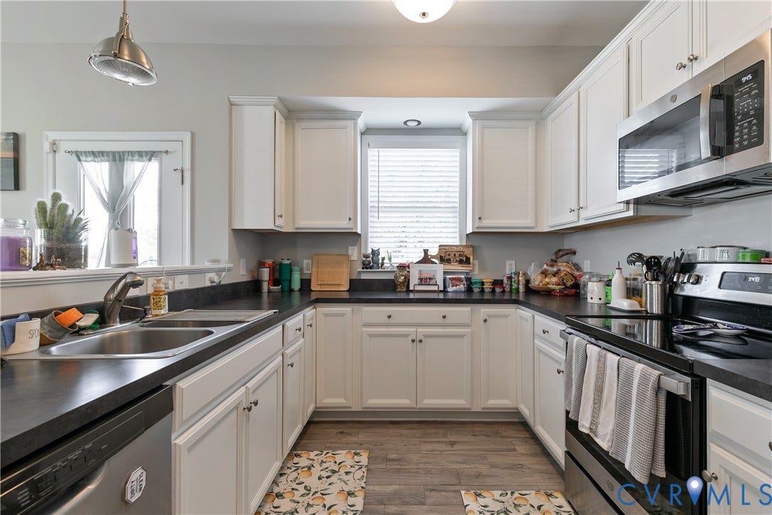 1301 Dance Street, Randolph, Richmond, VA 23220 U-shaped kitchen featuring white cabinetry, dark countertops, a stainless steel double basin sink, and a stainless steel oven/range with an above-range microwave