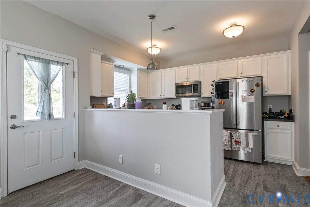 1301 Dance Street, Randolph, Richmond, VA 23220 Modern kitchen featuring white cabinetry, stainless steel appliances, wood-finish flooring, and a peninsula with countertop space