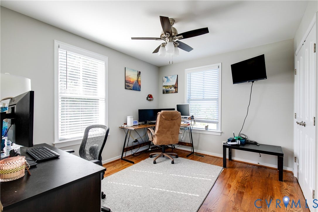 1301 Dance Street, Randolph, Richmond, VA 23220 Bright room featuring two windows with blinds, hardwood flooring, a ceiling fan with light fixture, and a white paneled door