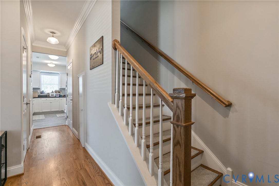 1301 Dance Street, Randolph, Richmond, VA 23220 Hardwood flooring throughout the hallway leads to a kitchen featuring white cabinetry and a window