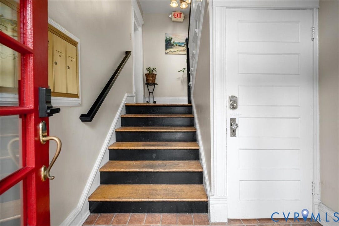 First floor staircase. Door to the right is to the Basement where each owner has a secured storage closet.