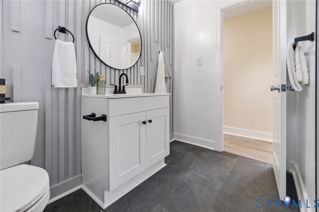 3122 Maplewood Avenue, Stadium, Richmond, VA 23221 Modern bathroom featuring a white vanity with black hardware, a circular mirror, and dark tile flooring
