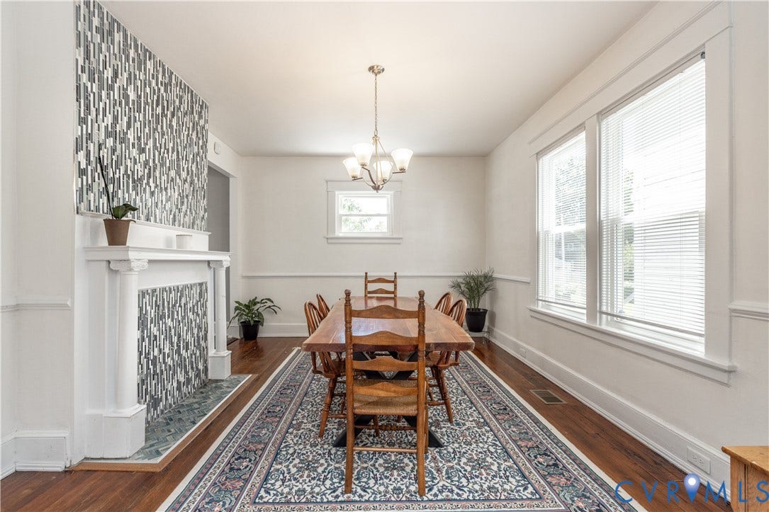 Dining area featuring a decorative fireplace with a mosaic tile surround and a classic white mantel
