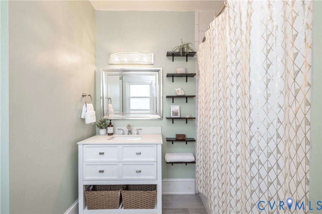 Bathroom featuring a white vanity with drawers, a single sink, and a countertop