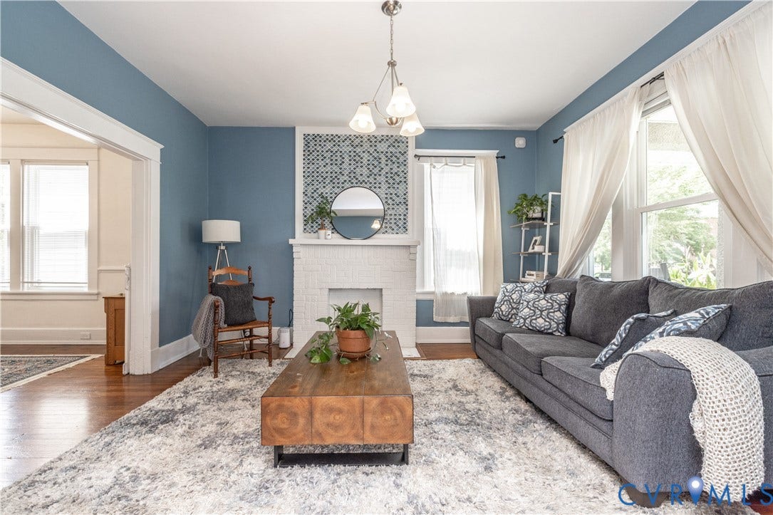 Living area featuring hardwood flooring and a white brick fireplace