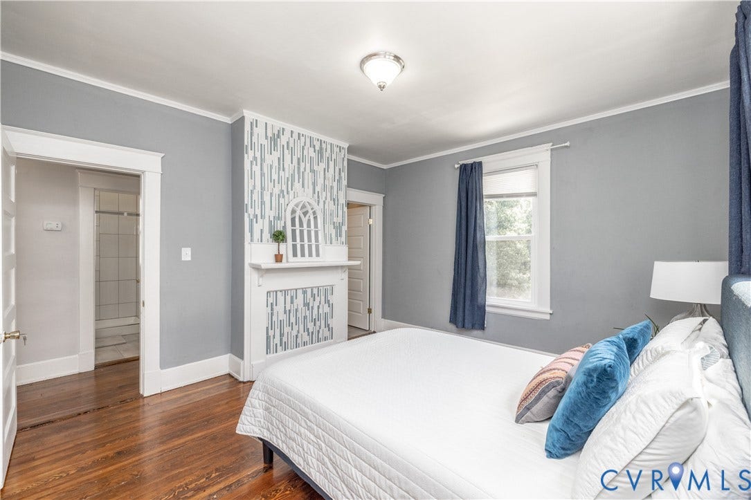 Hardwood flooring throughout featuring a decorative fireplace with a mosaic tile surround and mantel