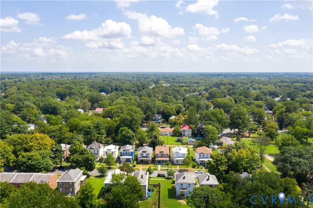 Expansive aerial perspective showcasing a residential neighborhood with mature tree coverage