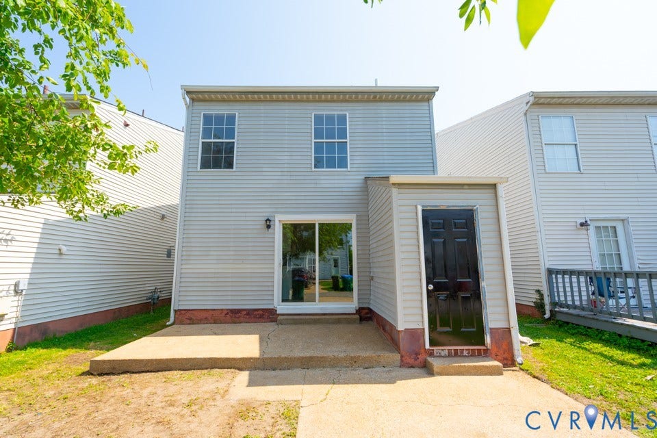 1409 Idlewood Avenue, Randolph, Richmond, VA 23220 Rear exterior featuring light gray siding, a concrete patio, and a sliding glass door