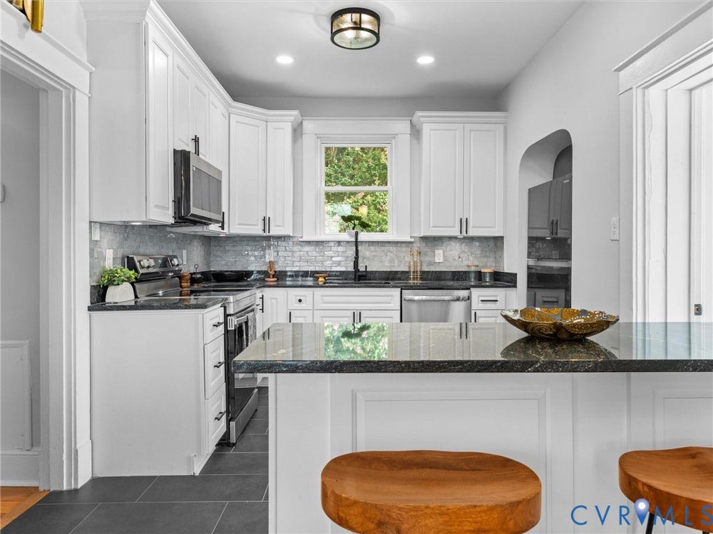 2911 Northumberland Avenue, Northside, Richmond, VA 23220 Kitchen featuring white cabinetry, dark stone countertops, stainless steel appliances, a tiled backsplash, and dark tile flooring