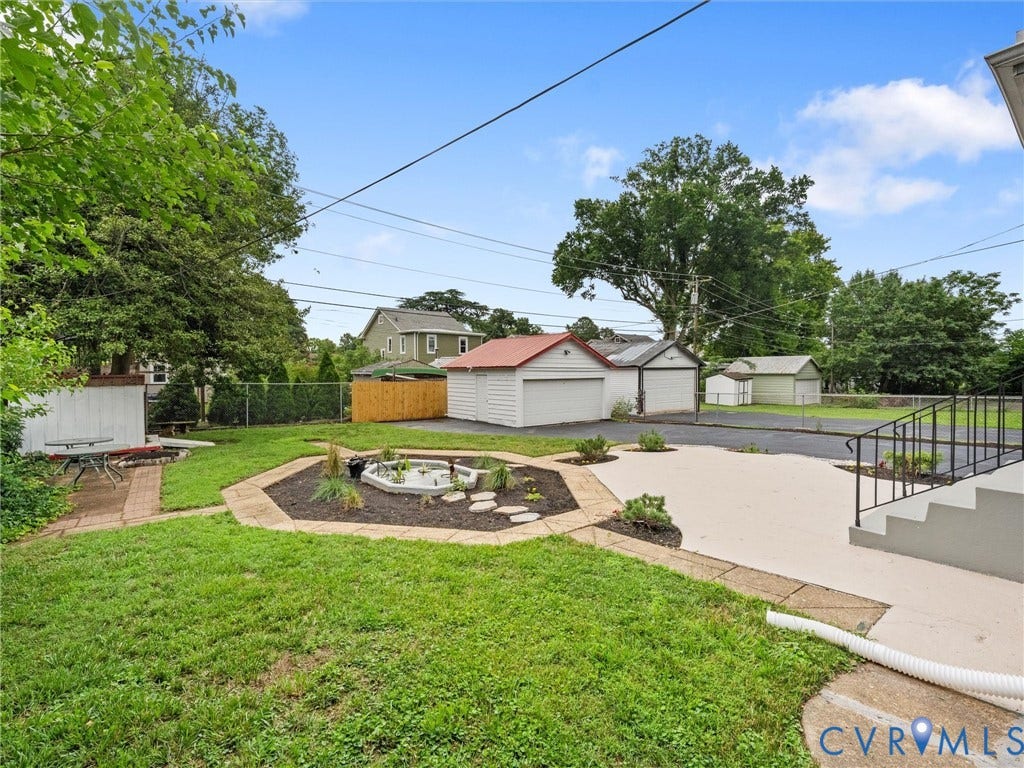 2911 Northumberland Avenue, Northside, Richmond, VA 23220 Expansive backyard featuring a concrete patio, a central garden bed, and a brick paver pathway