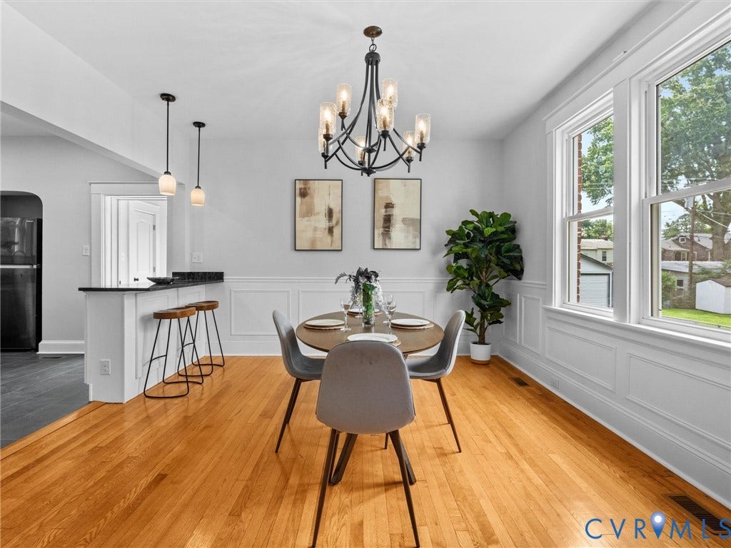 2911 Northumberland Avenue, Northside, Richmond, VA 23220 Dining area featuring hardwood flooring, wainscoting, an ornate chandelier, and multiple large windows