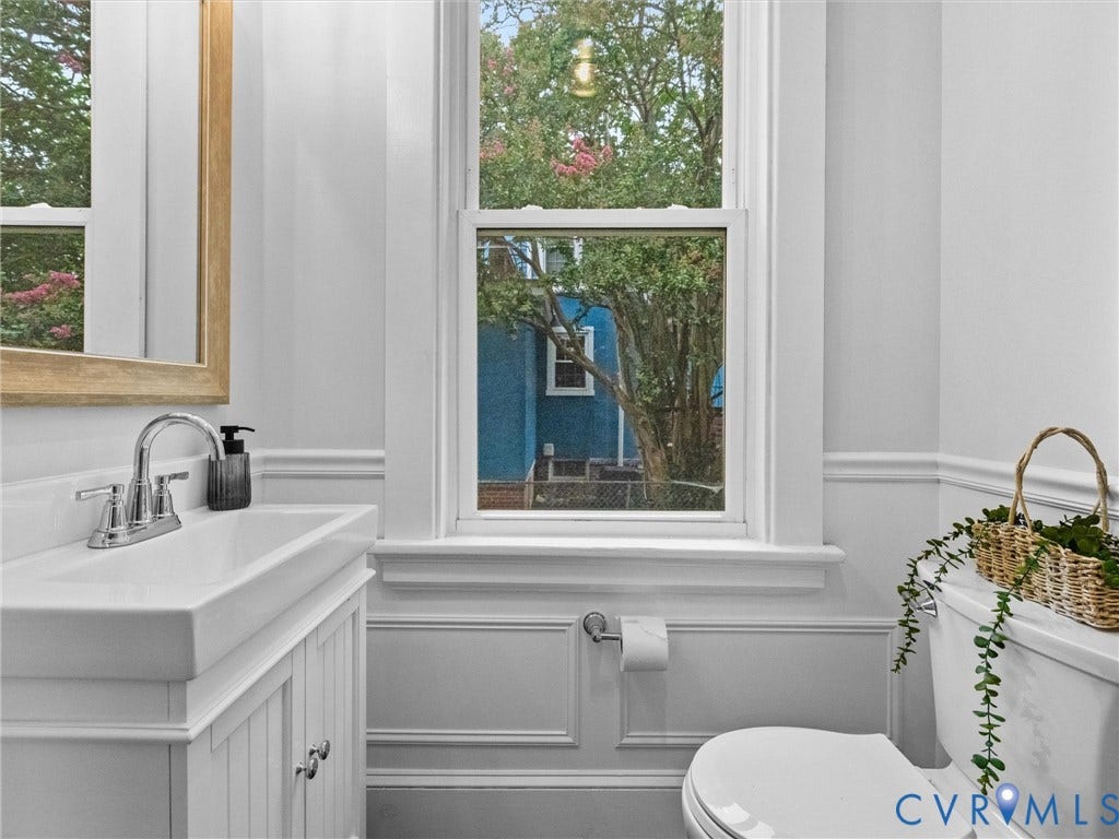 2911 Northumberland Avenue, Northside, Richmond, VA 23220 Bathroom featuring a window with natural light, a white vanity with an integrated sink and chrome faucet, wainscoting, and a toilet