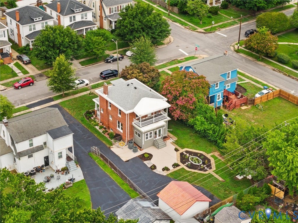 2911 Northumberland Avenue, Northside, Richmond, VA 23220 Brick facade home with multiple balconies, a paved patio, and a manicured lawn