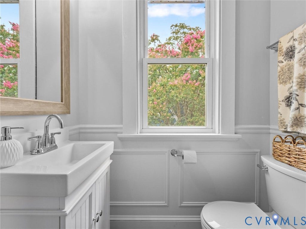 2911 Northumberland Avenue, Northside, Richmond, VA 23220 White vanity with an integrated rectangular sink and chrome faucet, set against wainscoting details and a window