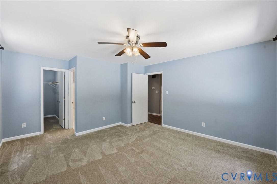 Carpeted room featuring light blue walls and a ceiling fan with light fixture