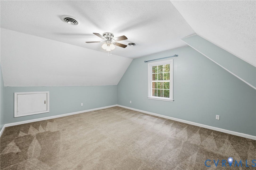 Spacious room with sloped ceilings and light blue wall finish