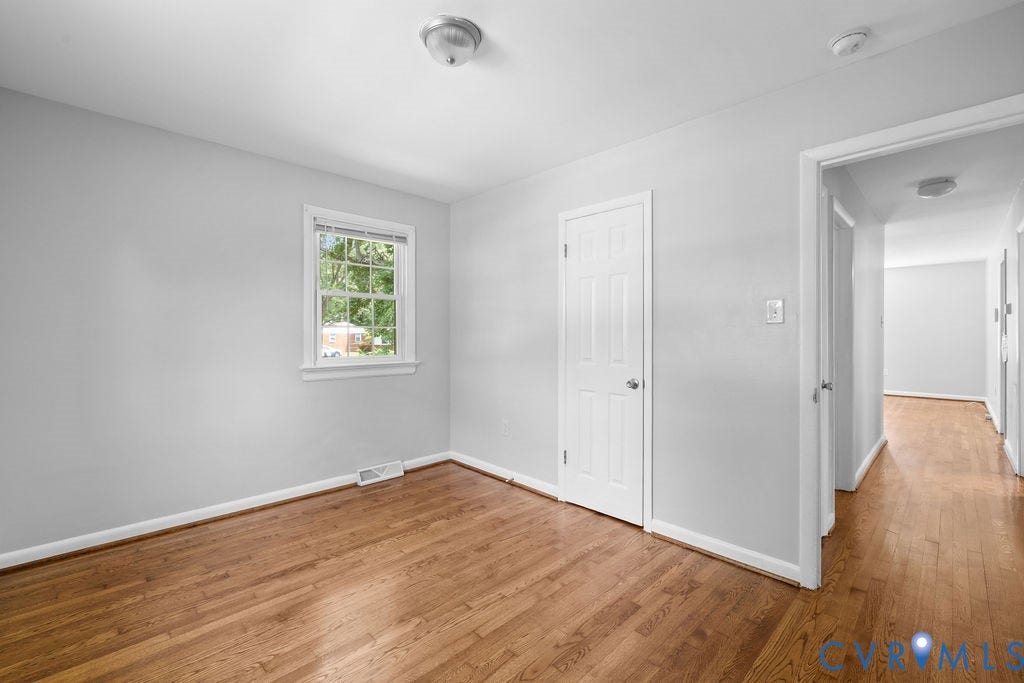 5527 Hansdale Road, Piney Knolls, Richmond, VA 23224 Room featuring wood-finish flooring, a six-panel door, and a single window with white trim