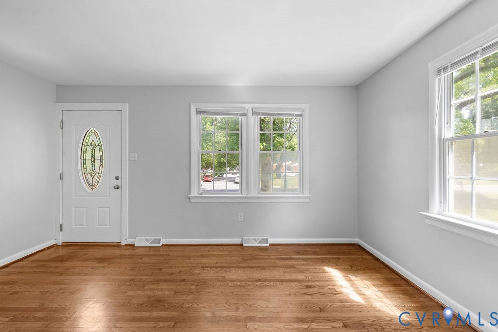 5527 Hansdale Road, Piney Knolls, Richmond, VA 23224 Bright living space featuring wood-finish flooring, white baseboards, and light gray wall paint