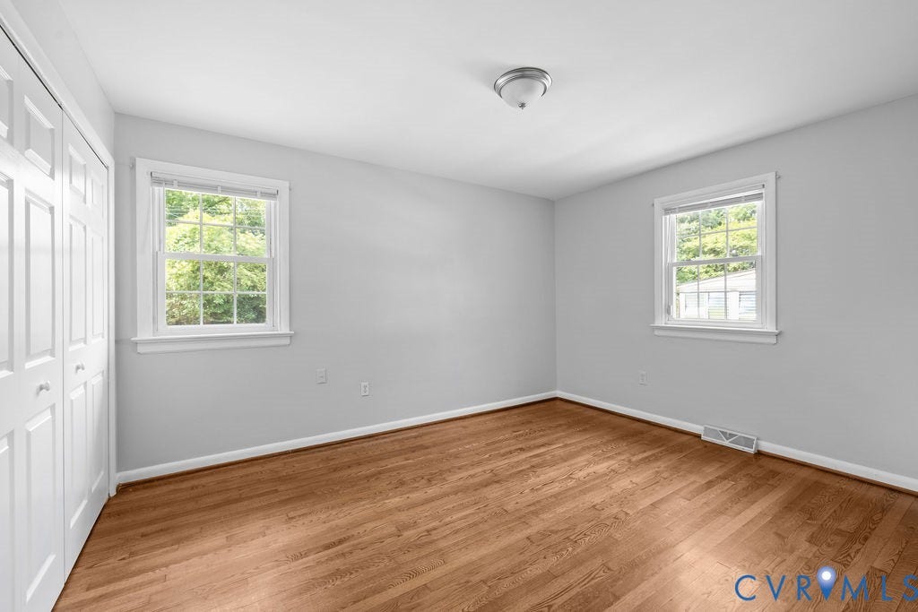 5527 Hansdale Road, Piney Knolls, Richmond, VA 23224 Room featuring wood-finish flooring, two double-hung windows, a ceiling light fixture, and bi-fold closet doors