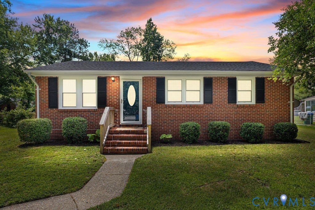 5527 Hansdale Road, Piney Knolls, Richmond, VA 23224 Classic brick ranch home featuring a dark shingle roof, black louvered shutters, an oval-lite front door, and established foundation plantings