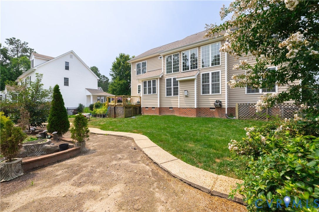 16814 Jennway Place, Moseley, VA 23120 Rear exterior featuring a large expanse of green lawn, multiple windows across two levels, and a concrete pathway