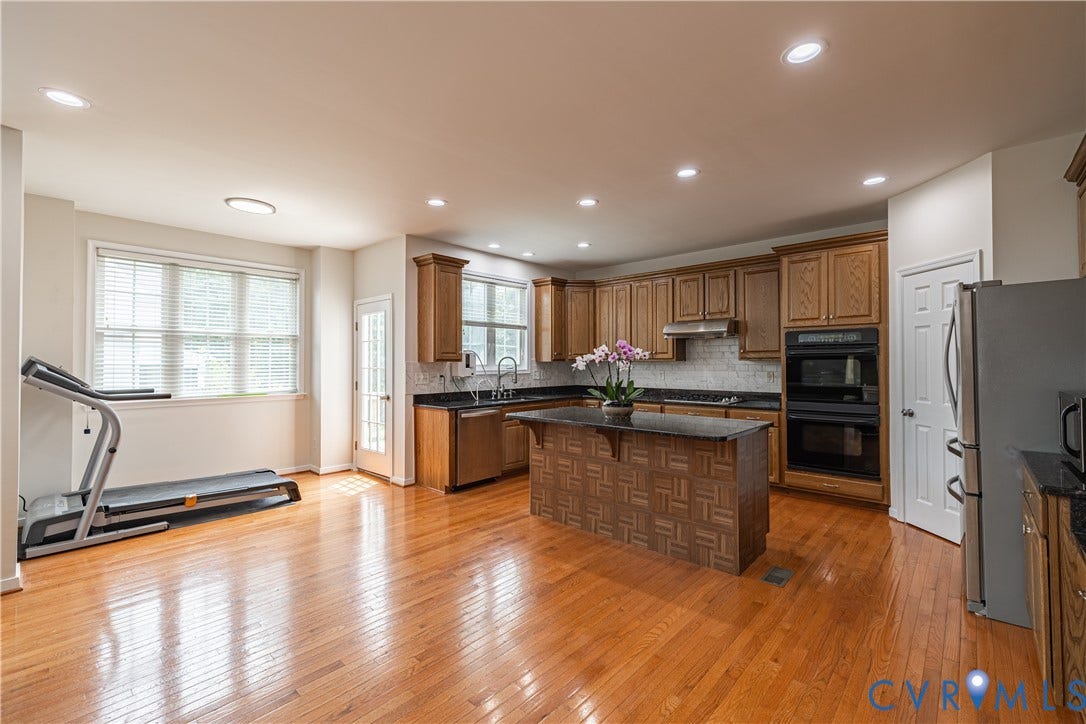 16814 Jennway Place, Moseley, VA 23120 Kitchen featuring wood-finish flooring, recessed lighting, and a central island with a dark countertop
