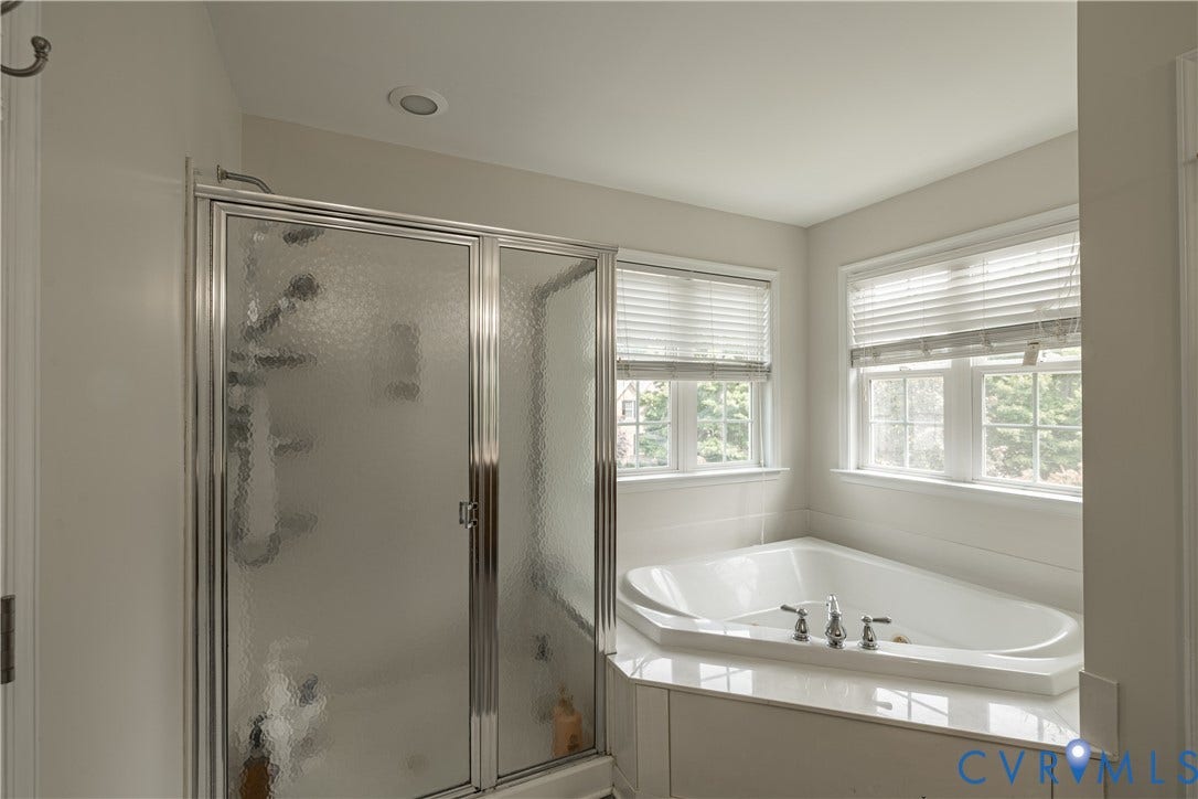 16814 Jennway Place, Moseley, VA 23120 Corner soaking tub with deck-mounted chrome fixtures, surrounded by a tiled wall and two windows