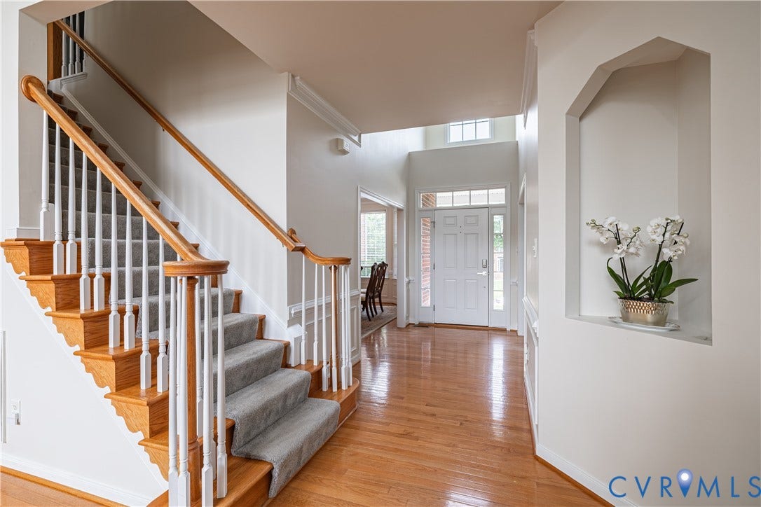 16814 Jennway Place, Moseley, VA 23120 Bright foyer with wood-finish flooring, a grand staircase with wood handrails, and a decorative wall niche