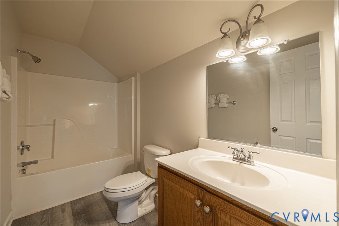 16814 Jennway Place, Moseley, VA 23120 Bathroom featuring a white tub-shower combination, a toilet, and a vanity with a white countertop and wood-finish cabinetry