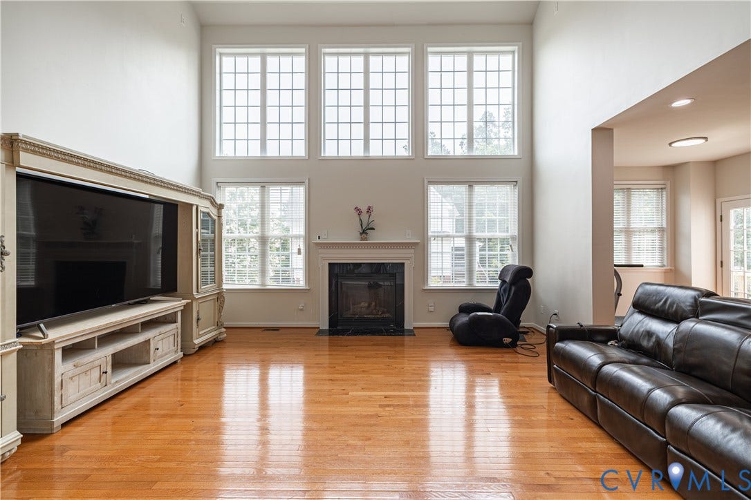 16814 Jennway Place, Moseley, VA 23120 Two-story living area featuring wood-finish flooring, a fireplace with a mantel, and multiple windows