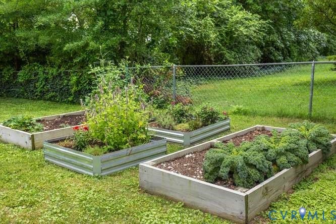 Backyard garden area featuring three raised garden beds, two constructed from wood and one from galvanized metal