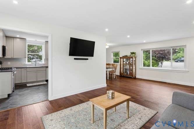 Open concept living area featuring dark wood-finish flooring, recessed lighting, and expansive windows