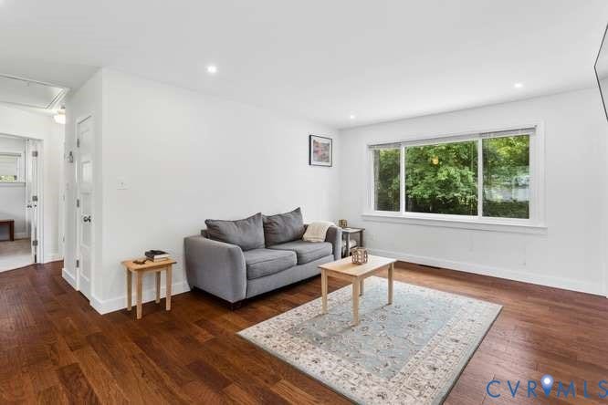 Bright living area with wood-finish flooring and recessed lighting