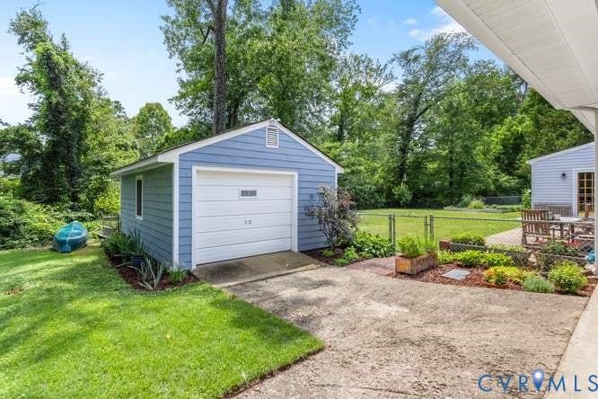 Detached blue siding garage featuring a white overhead door with rectangular window inserts