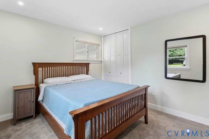 Light-filled room featuring recessed lighting, a white framed window, and a built-in closet with bifold doors