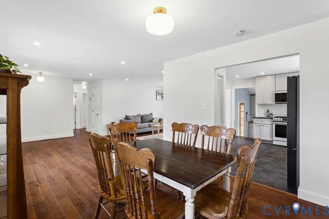 Expansive room featuring wood-finish flooring and recessed lighting