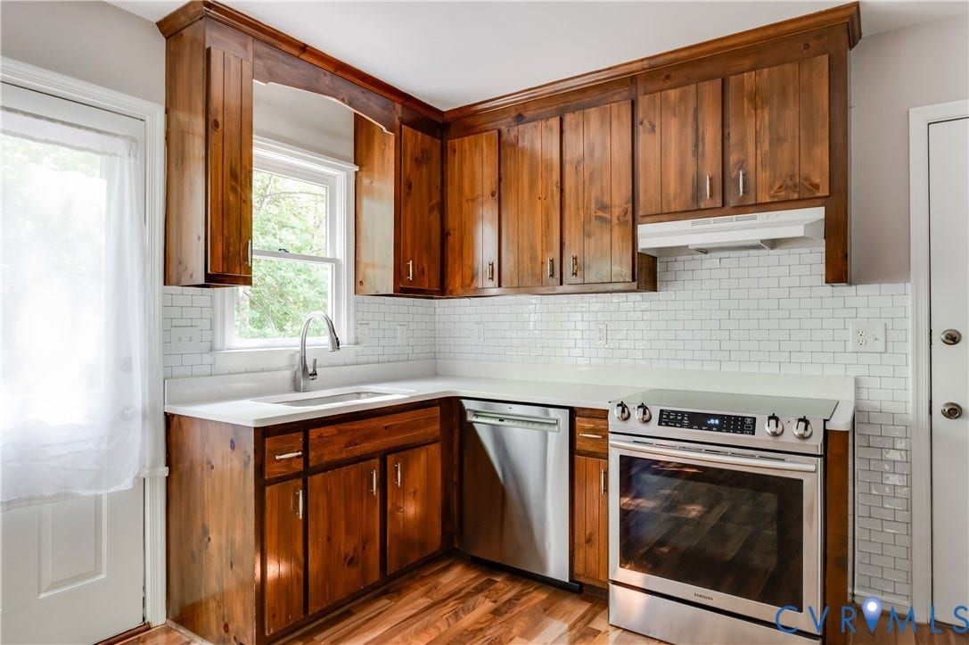 4419 Boones Bluff Way, Chesterfield, VA 23832 Kitchen featuring wood-finish cabinetry, white countertops, a subway tile backsplash, stainless steel appliances, and wood-finish flooring