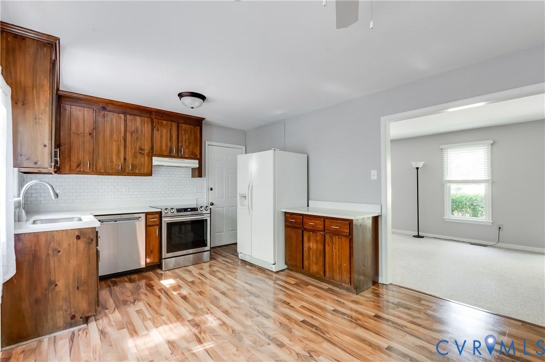 4419 Boones Bluff Way, Chesterfield, VA 23832 Kitchen featuring wood-finish cabinetry, white subway tile backsplash, stainless steel appliances, and wood-finish flooring