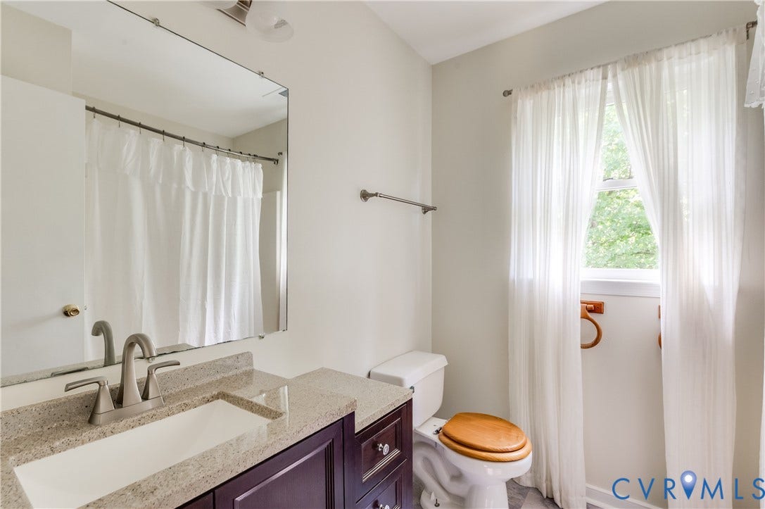 4419 Boones Bluff Way, Chesterfield, VA 23832 Bathroom featuring a dark wood-finish vanity with a light speckled countertop, an undermount rectangular sink, and a brushed nickel faucet