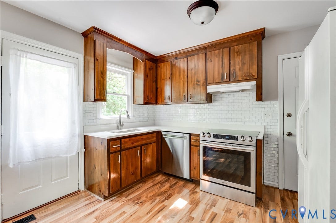 4419 Boones Bluff Way, Chesterfield, VA 23832 Kitchen featuring wood-finish cabinetry, light countertops, subway tile backsplash, stainless steel appliances, and wood-finish flooring