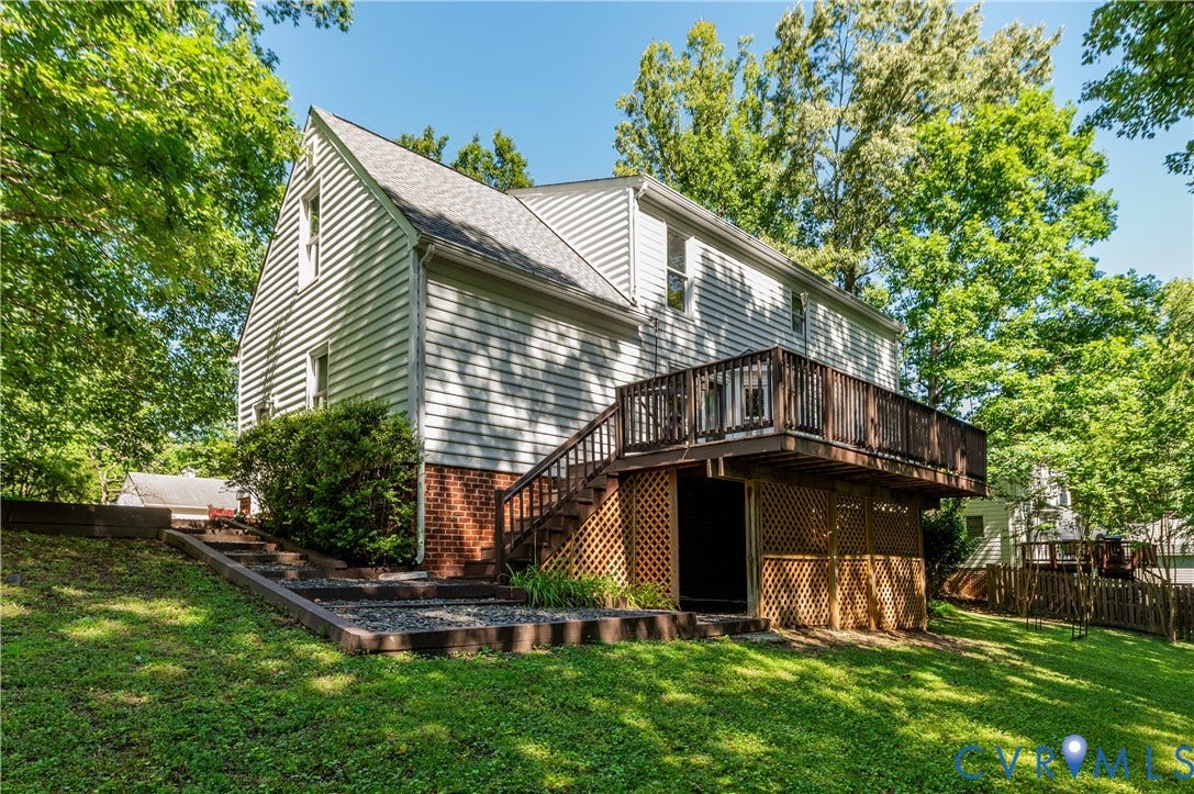 4419 Boones Bluff Way, Chesterfield, VA 23832 Rear exterior featuring a spacious wood deck with railing, stairs to yard access, and a lattice-enclosed under-deck storage area