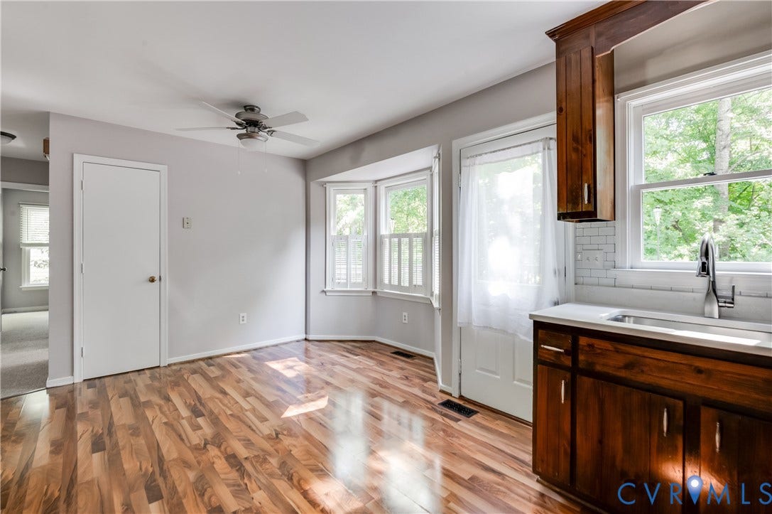 4419 Boones Bluff Way, Chesterfield, VA 23832 Open-concept space featuring wood-finish flooring, a bay window with natural light, and a ceiling fan