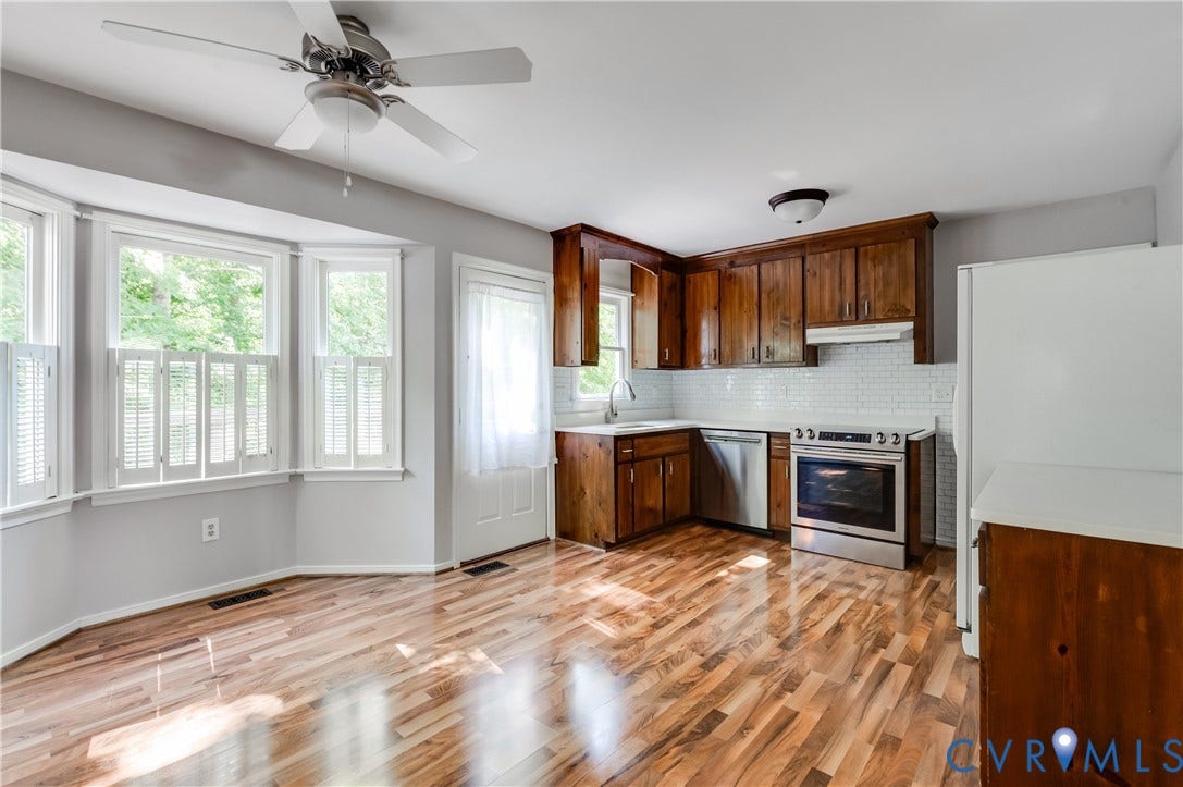 4419 Boones Bluff Way, Chesterfield, VA 23832 Kitchen and dining area featuring wood-finish flooring, a bay window with white plantation shutters, and a ceiling fan
