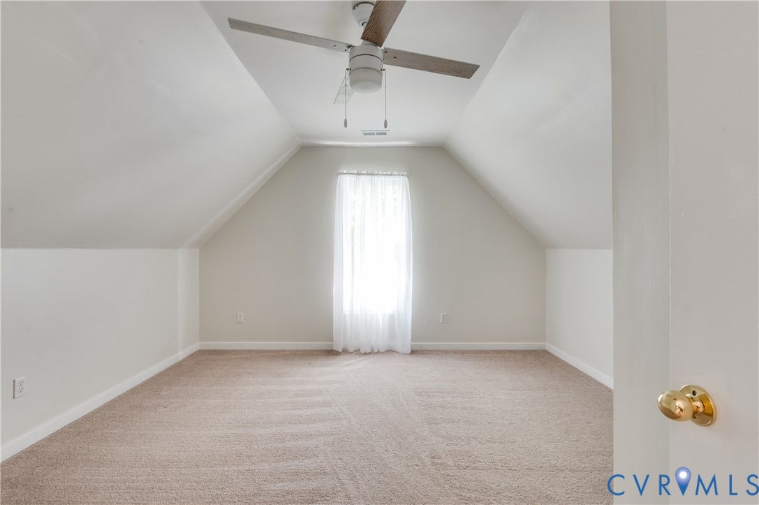 4419 Boones Bluff Way, Chesterfield, VA 23832 Spacious room featuring sloped ceilings, a centered window with sheers, and a ceiling fan with light fixture