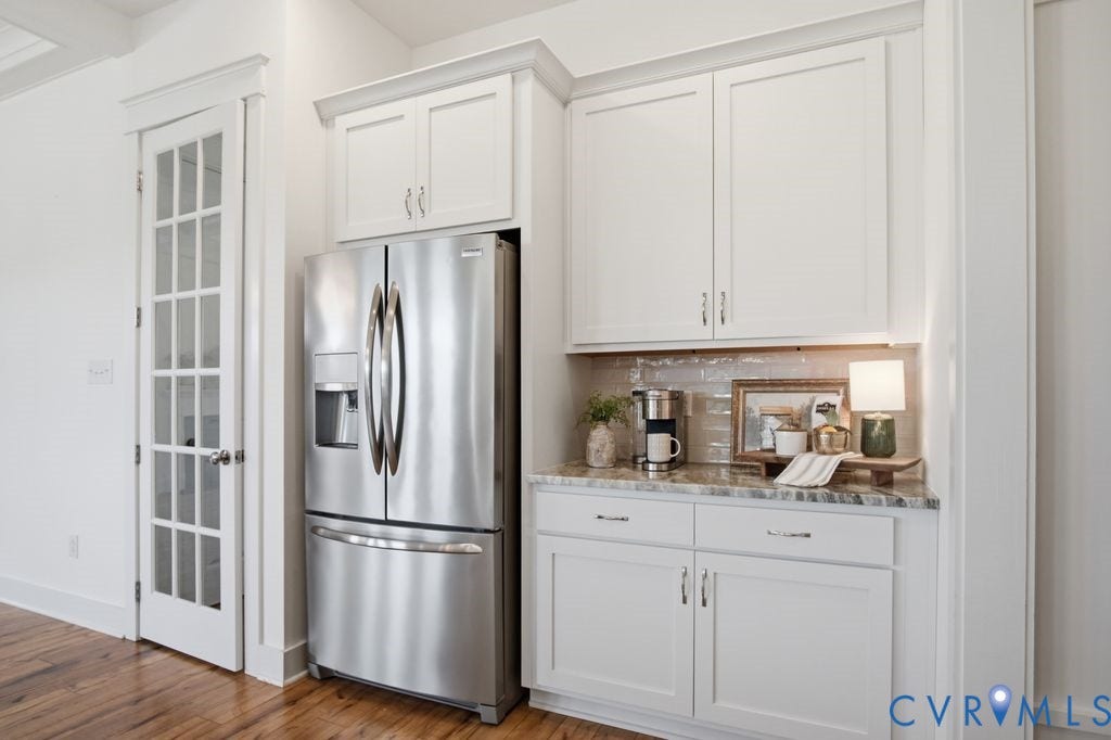 6991 Carden Park Drive, Carden Park, Moseley, VA 23120 Built-in beverage station featuring white cabinetry, a stone countertop, a tiled backsplash, and stainless steel appliances
